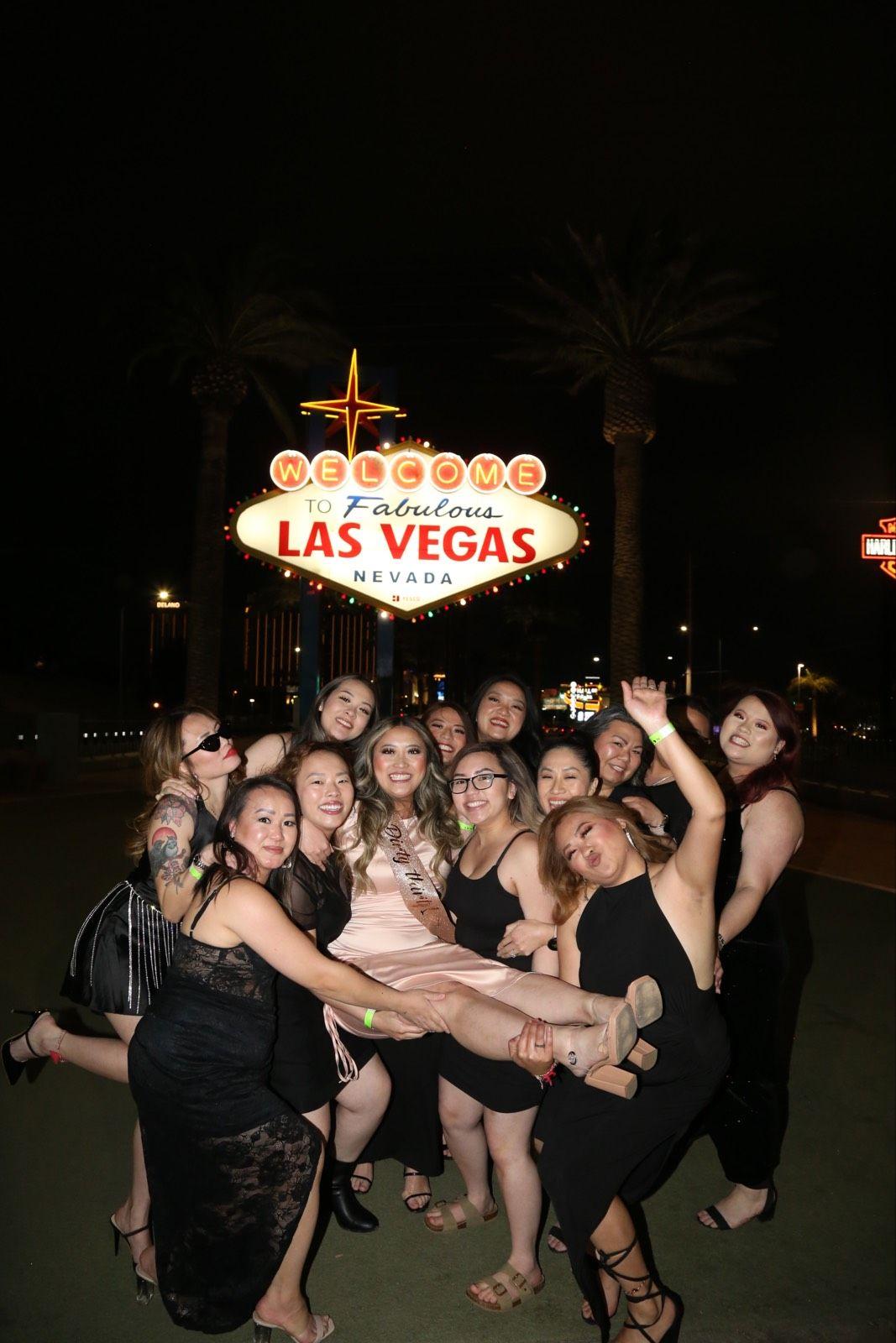 Group of women celebrating a thirtieth birthday party in front of the Welcome to Fabulous Las Vegas sign during a Crawl Group event