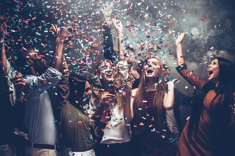 Group of people celebrating with confetti at a Las Vegas nightclub, representing the vibrant nightlife experiences offered by Crawl Group.